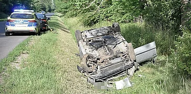 Leżące na dachu auto - wewnątrz zakleszczony, ranny mężczyzna